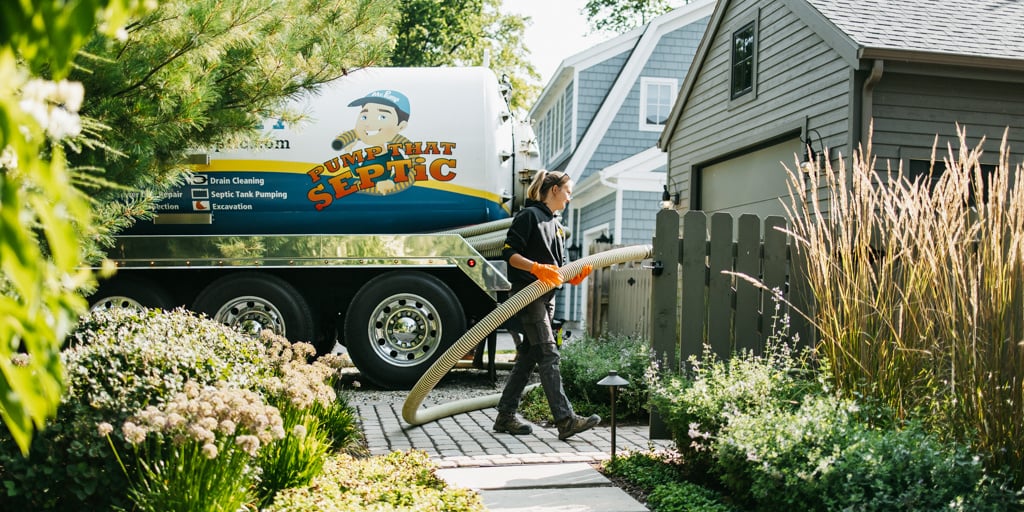 a technician unloads hoses for pumping a residential septic tank